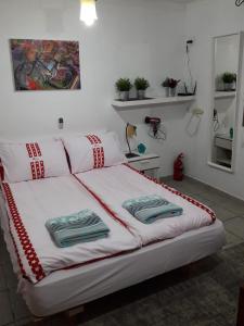 a white bed with towels on it in a room at kibbutz hatzor A room close to Ashdod in H̱aẕor Ashdod