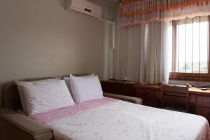 sypialnia z łóżkiem z białą pościelą i oknem w obiekcie Av das hortênsias 3 quartos 3 banheiros w mieście Gramado