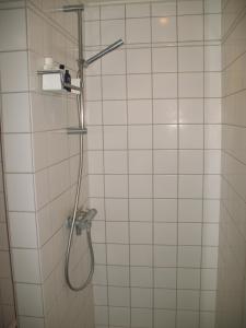 a shower in a white tiled bathroom at Esben Juhls Guest Room in Copenhagen