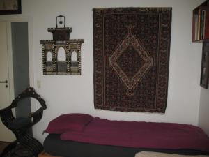 a bedroom with a bed and a rug on the wall at Esben Juhls Guest Room in Copenhagen