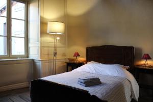 1 dormitorio con 1 cama con lámpara y 2 mesas en La Rapiette de Noblat, en Saint-Léonard-de-Noblat