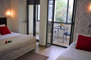 a bedroom with two beds and a table and a window at Universo Romantico in Lisbon