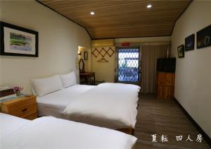 
a hotel room with a bed and a desk at 玉蟾園民宿 寵物友善 YuChanYuan B&B in Chishang
