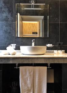 a bathroom with a sink and a mirror and towels at Via Veneto Suites in Rome