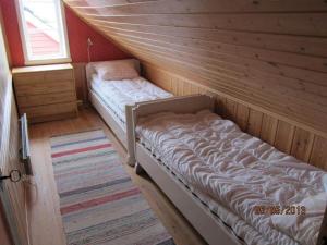 a room with two beds in a wooden cabin at Presthus Gård in Ølve