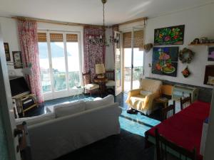 ein Wohnzimmer mit Sofa, Stühlen und Fenstern in der Unterkunft Casa Formis in Levanto