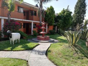 a statue of a cow in front of a building at Villas Hotel Cholula in Cholula +4 photos