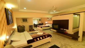 马尼帕尔Hotel Ashlesh Manipal的一间带床和电视的客厅