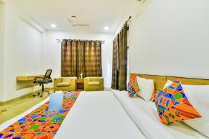 um quarto com uma cama, uma secretária e uma cadeira em FabHotel Rallkmas Cyber City em Gurgaon