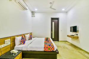 een slaapkamer met een bed en een televisie. bij FabHotel Rallkmas Cyber City in Gurgaon