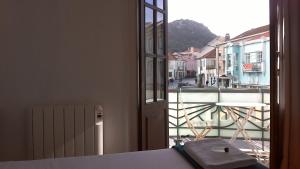 a room with a window with a view of a city at Casa Azul Hostel in Sintra