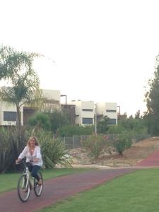 Eine Frau, die auf einem Bürgersteig Fahrrad fährt. in der Unterkunft Citadela I, Golfe, Pool and Falesia Beach in Vilamoura