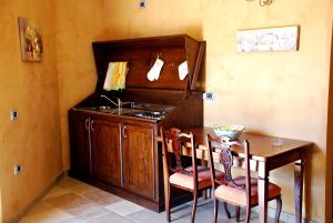 a kitchen with a table and a sink and a table and chairs at Agriturismo Casacchella in San Nico
