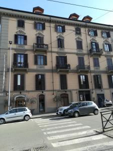 ein großes Gebäude, vor dem Autos parken in der Unterkunft ALICE HOME in Turin