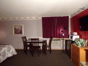 um quarto com uma mesa e cadeiras e um quarto em Morton Inn em Redwood Falls