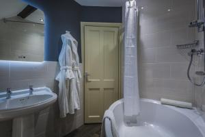 a bathroom with a sink and a toilet and a shower at The Castle Hotel, Conwy, North Wales - The Coaching Inn Group in Conwy