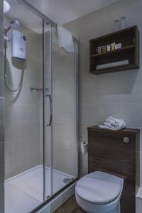 a bathroom with a toilet and a glass shower at The Castle Hotel, Conwy, North Wales - The Coaching Inn Group in Conwy