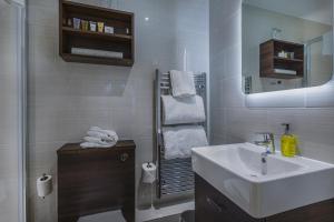 a white bathroom with a sink and a mirror at The Castle Hotel, Conwy, North Wales - The Coaching Inn Group in Conwy