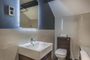 a bathroom with a sink and a toilet and a mirror at The Castle Hotel, Conwy, North Wales - The Coaching Inn Group in Conwy
