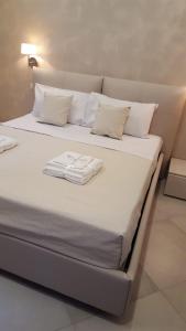 un letto con lenzuola e cuscini bianchi di Appartamenti Borgo Panoramico n.1 a Tropea