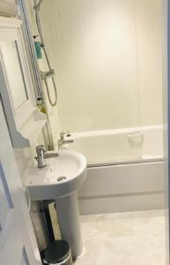 a white bathroom with a sink and a bath tub at Melbourne View Hotel in Melbourne