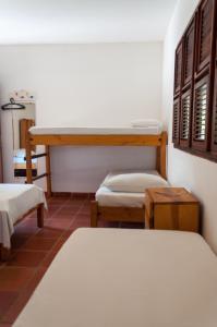 Cette chambre comprend 2 lits jumeaux et une table. dans l'établissement Jangada Lodge, à São Miguel do Gostoso