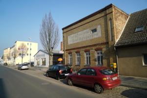 two cars parked in front of a brick building at klassMo Gästehaus in Luckenwalde