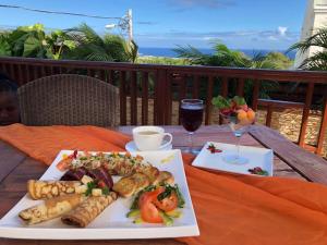 una mesa con dos platos de comida y una copa de vino en Palm Spring Inn, en Oranjestad