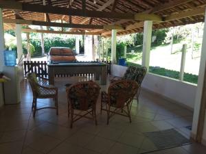 eine Gruppe Stühle und ein Tisch auf einer Veranda in der Unterkunft Chácara do Delei in São Luiz do Paraitinga