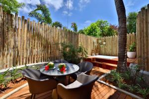 a patio with a table and chairs and a fence at Pousada Zé Maria in Fernando de Noronha