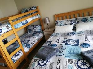 a bedroom with two bunk beds and a lamp at The White House Apartment in Mossel Bay