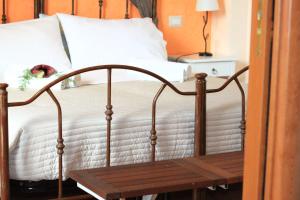 sypialnia z łóżkiem z białą pościelą i drewnianą ławką w obiekcie Oasi del Lago w mieście Regalbuto