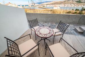 eine Terrasse mit einem Tisch und Stühlen auf dem Balkon in der Unterkunft Apartmani Matej B in Pag