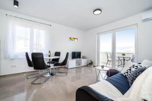 ein Wohnzimmer mit einem Sofa, Stühlen und einem Tisch in der Unterkunft Apartmani Matej B in Pag