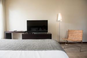 a bedroom with a bed and a lamp at 27 Suites in Montevideo