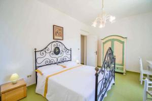 una camera con un grande letto e un lampadario a braccio di Villa Scarnera by BarbarHouse a Corsano