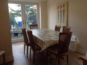 a dining room table and chairs with a table and a window at Cricket View cottage in Redcar