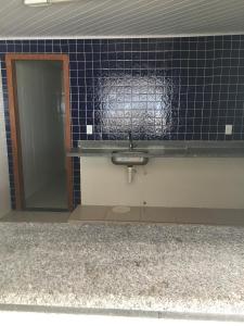 uma casa de banho com um lavatório e um espelho em Ed. Barra Shopping em Marataízes