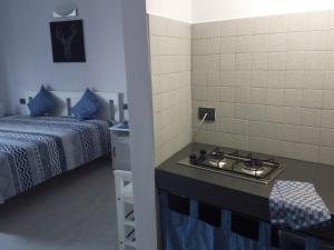 a kitchen with a stove in a room with two beds at Casafaty in Palazzolo Acreide