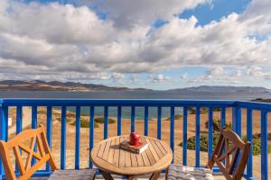 een tafel en stoelen op een balkon met uitzicht op de oceaan bij Polyegos View in Pollonia