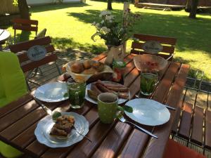 einem Holztisch mit Teller mit Lebensmitteln darauf in der Unterkunft Pension Zum alten Gasthaus Hänsel in Krauschwitz