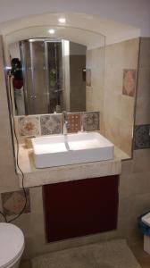 La salle de bains est pourvue d'un lavabo blanc et d'un miroir. dans l'établissement B&b il castello, à Giovinazzo