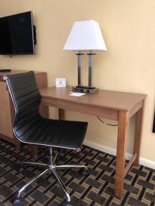 a desk with a lamp and a chair at SureStay Hotel by Best Western Clermont Theme Park West in Kissimmee
