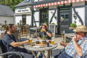 a group of men sitting at a table with drinks at Historische Mühle Vogelsang in Brodenbach