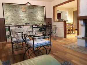 - un salon avec une table, des chaises et une cheminée dans l'établissement La Cahute, à Pontarlier