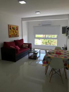 ein Wohnzimmer mit einem roten Sofa und einem Tisch in der Unterkunft Departamento Rodrigo II in Posadas