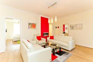 a living room with white furniture and red walls at Villa Livia Whg 02 in Ahlbeck