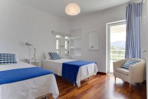 a bedroom with two beds and a chair and a window at Beautiful, Private Villa by the Sea in Aghia Marina +55 photos