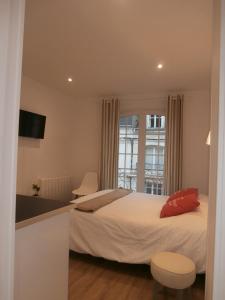 Habitación de hotel con cama y ventana en au Claire de lune, en Dieppe