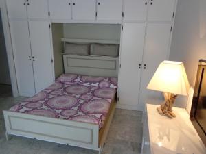 a small bedroom with a bed and a lamp at Residence Albert Premier in Menton